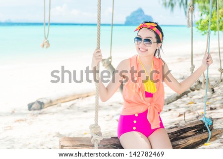 A portrait of beautiful asian sit on swing at the sea