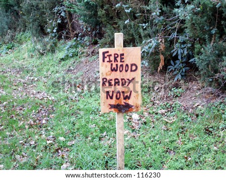 Sign farm sign lane lettering hedge row logs trees fire wood