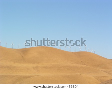 golden hills in california with windmills all over to generate electricity