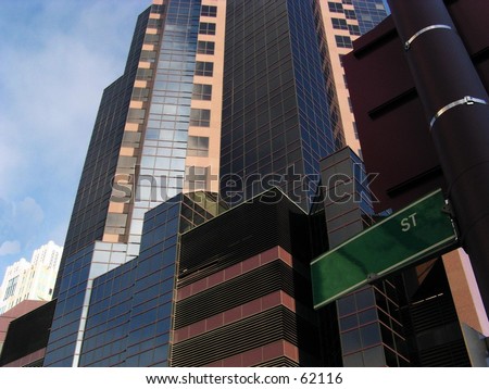 Huge glass building with blank street sign in front of it for you to fill in.