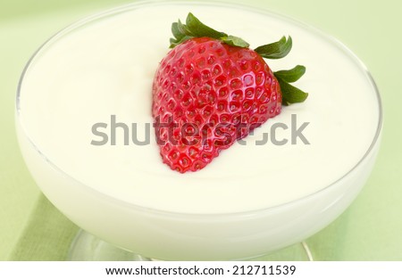 Healthful yogurt and ripe strawberry as a snack or desert.