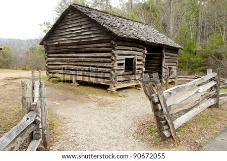 Rustic log shed with split rail fence