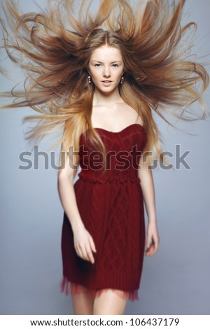 Fine art fashion portrait of blond fashion model posing with hair fluttering in the wind, shallow deep of field