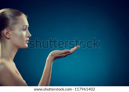 Beauty Care. Beauty portrait of beautiful gorgeous woman showing empty open hand palm over blue background