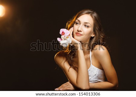 Woman beauty face closeup portrait with orchids looking to the side at blank copy space