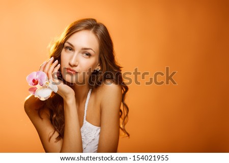 Woman beauty face closeup portrait with orchids looking to the side at blank copy space