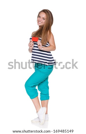 Positive teen girl hipster in casual summer clothes standing in full length and showing blank credit card, over white background