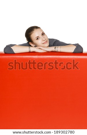 Calm relaxed woman leaning on the red leather couch