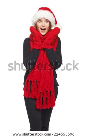 A beautiful happy surprised Christmas woman wearing santa hat and red scarf and mittens shouting of joy, over white background