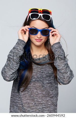 Happy smiling woman wearing many colourful sunglasses