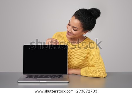 Happy mixed race african american - caucasian woman showing blank black laptop computer screen, looking at screen