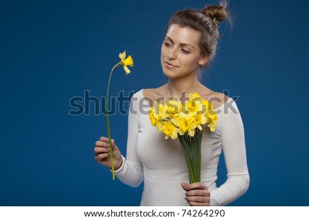 Young female with bunch of flowers on blue background, special flower