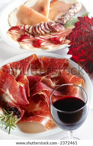 Prosciutto and different salami products with red wine