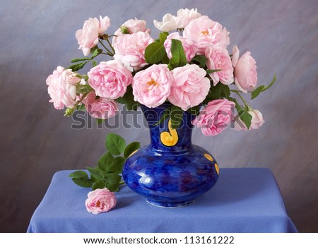 Still life with tea roses bunch in vase on artistic background