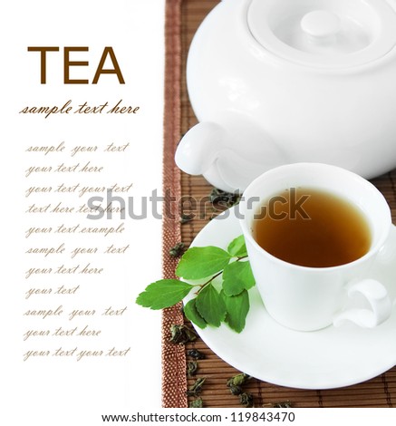 Cup of green tea with kettle and fresh green leaves isolated on white background