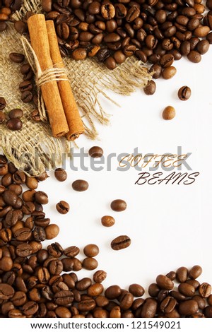 Coffee beans background with cinnamon and sacking material isolated on white with sample text
