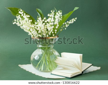 Still life with lily of the valley bunch and book