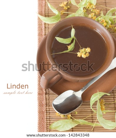 Healthy linden tea breakfast (cup of tea, with linden blossom flower and spoon on bamboo mat isolated on white background)
