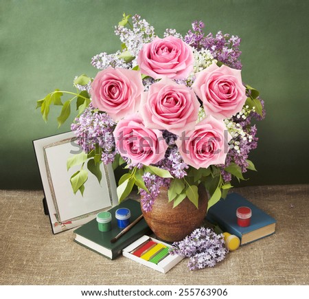 Still life with lilac and rose flowers bunch, book and painting on artistic background. Teacher Day