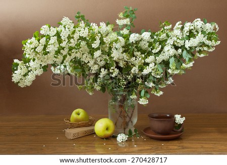 Still life with blossom tree flowers, tea in cup, fan and apples on artistic background