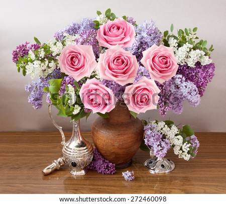 Still life with roses and lilac flowers on artistic background