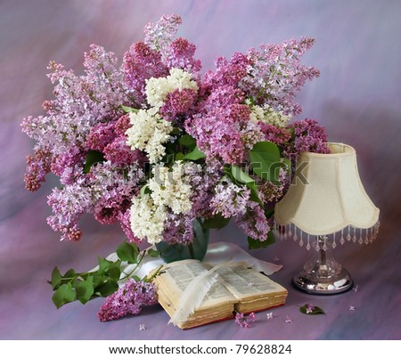 Still life with lilac, book and lamp on artistic background