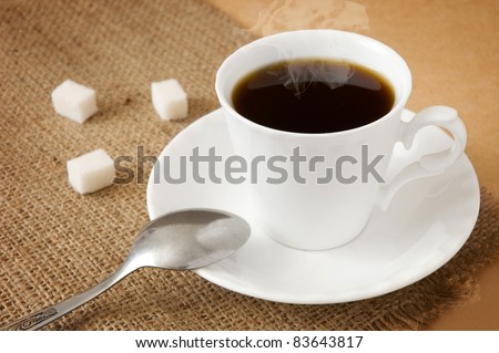 Cup of hot coffee with sugar and spoon