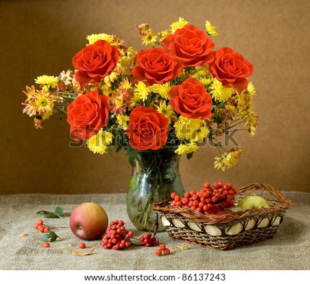 Still life with huge bunch of autumn flowers and red roses, apples and rowan berries