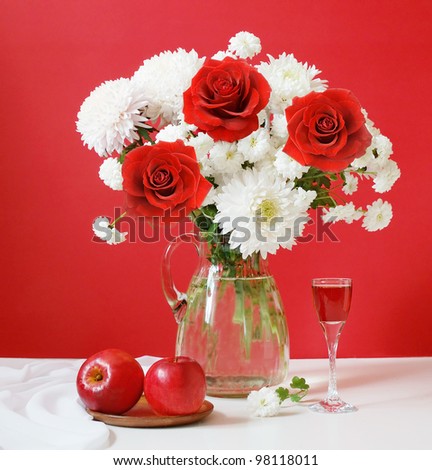 Still life with huge bunch of white flowers and red roses, apples and wine on artistic background