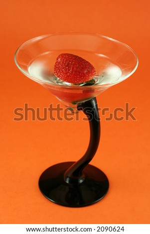 strawberry in cold water, elegant gin glass on orange background