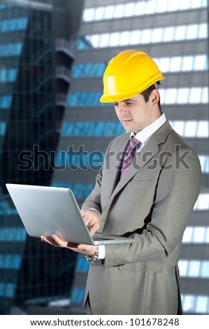 Construction contractor businessman using notebook in front of modern corporate building.