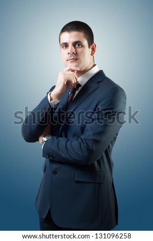 Portrait of young good looking male, posing like politician or businessman. Standing and looking at camera.