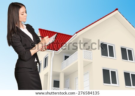 Office girl holding clip board standing on background of the house.