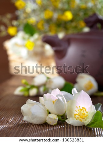 Jasmine tea in oriental teapot with fresh jasmine flowers.