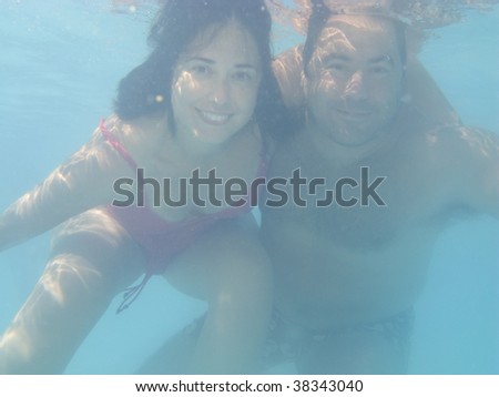 Lovely couple underwater on a swimmingpool, underwater photo