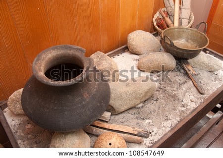 old style cooking food in jar with stone and fire