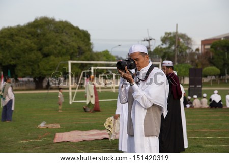 YALA, THAILAND - AUGUST 8 : Thai Muslim male photographer take a picture before pray for Allah Islamic God in Hari Raya Day Idil Fitri 1434 H. on Aug 8, 2013 at Yala Youth Center, Thailand
