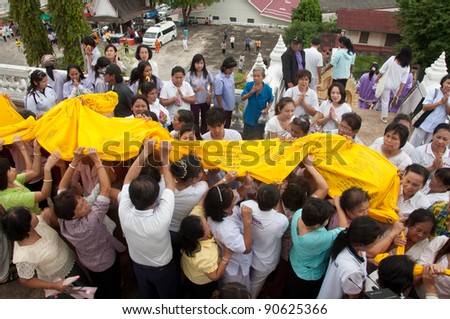 YALA, THAILAND - DECEMBER 10: Unidentified people carry holy fabric in Huakuan Temple Pagoda celebration ceremony for king Bhumibol Adulyadej Birthday on Dec 10, 2011 at Yala Huakuan Temple, Thailand