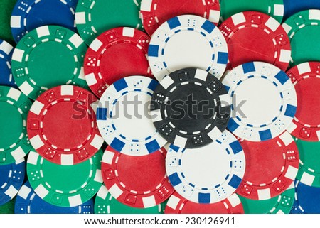 Beautiful flower tower made of Black, White, Green, Blue and Red Playing Poker Chips in a green background