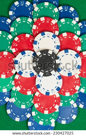 Beautiful flower tower made of Black, White, Green, Blue and Red Playing Poker Chips in a green background