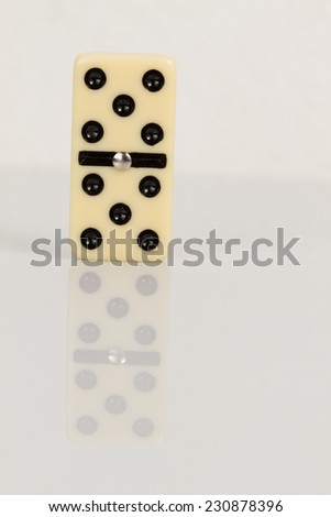 Five Close up of domino pieces with black dots in reflective white background