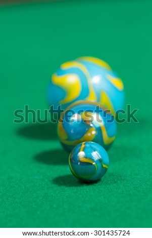 Bigger to smaller yellow and blue Marble Balls on green background