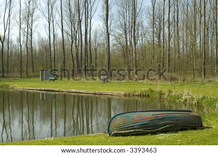 Fishing pond with a boat and trees