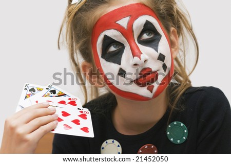 Young girl painted a colorful poker face playing cards game