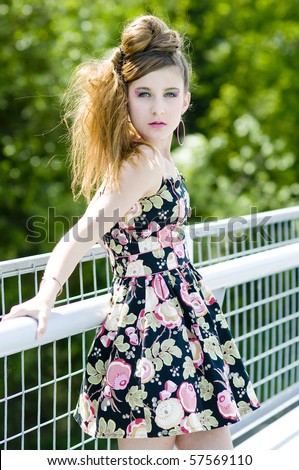 Teenager girl model presenting clothes in the park natural background