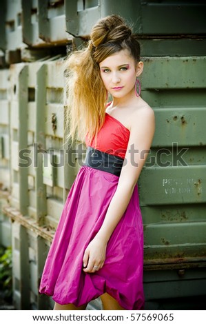 Teenage girl model presenting flashy clothes in old natural background