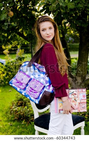 Back to school fashion girl showing bags, class book and accessories