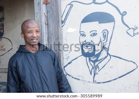 LANGA TOWNSHIP, SOUTH AFRICA - JULY 12, 2015 - A local barber poses for a photograph outside of his shop in Langa, South Africa, a township located on the outskirts of Cape Town.