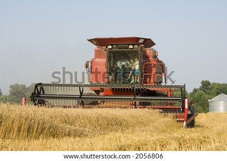 A farmer gives his family a ride in a combine in a wheat field in central Illinois