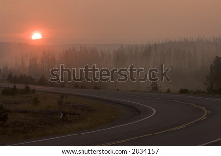 The sun rises over a roadway in Yellowstone national park